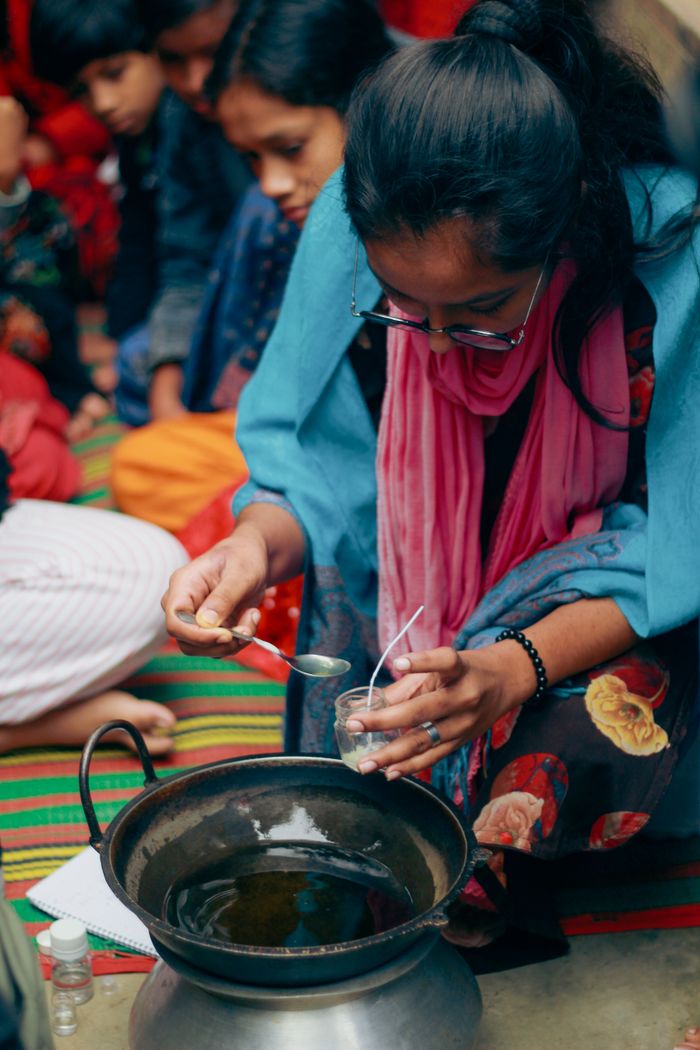 Young girls in Dhaka learn eco-friendly candle making through hands-on training.